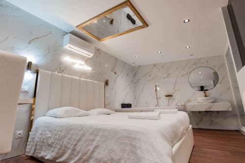 Séjour de Luxe à Saint-Jean-Bonnefonds : Chambre Dubaï** Vivez un séjour de luxe dans notre chambre Dubaï, offrant une vue magnifique sur la nature, à Saint-Jean-Bonnefonds, près de Saint-Étienne dans la Loire. Plongez dans une atmosphère de sophistication avec des murs en marbre blanc et doré, créant une ambiance luxueuse et minimaliste. Détendez-vous dans notre jacuzzi tout en admirant la vue panoramique, puis profitez d'une soirée cinéma sur notre grand écran de 189 cm avec Netflix, pour une expérience inoubliable.