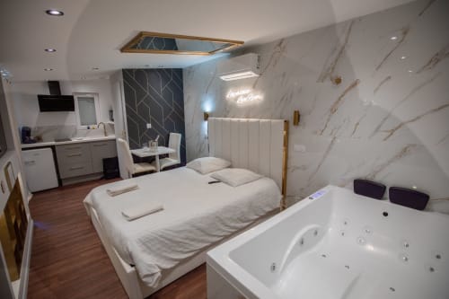 Séjour de Luxe à Saint-Jean-Bonnefonds : Chambre Dubaï** Vivez un séjour de luxe dans notre chambre Dubaï, offrant une vue magnifique sur la nature, à Saint-Jean-Bonnefonds, près de Saint-Étienne dans la Loire. Plongez dans une atmosphère de sophistication avec des murs en marbre blanc et doré, créant une ambiance luxueuse et minimaliste. Détendez-vous dans notre jacuzzi tout en admirant la vue panoramique, puis profitez d'une soirée cinéma sur notre grand écran de 189 cm avec Netflix, pour une expérience inoubliable.