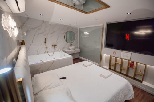 Séjour de Luxe à Saint-Jean-Bonnefonds : Chambre Dubaï** Vivez un séjour de luxe dans notre chambre Dubaï, offrant une vue magnifique sur la nature, à Saint-Jean-Bonnefonds, près de Saint-Étienne dans la Loire. Plongez dans une atmosphère de sophistication avec des murs en marbre blanc et doré, créant une ambiance luxueuse et minimaliste. Détendez-vous dans notre jacuzzi tout en admirant la vue panoramique, puis profitez d'une soirée cinéma sur notre grand écran de 189 cm avec Netflix, pour une expérience inoubliable.