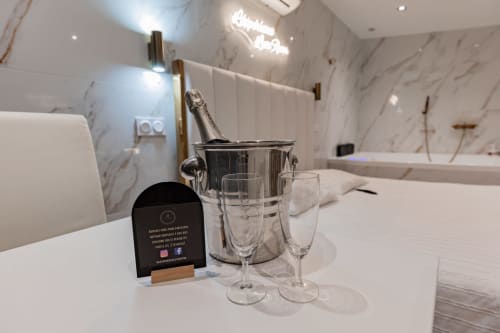Séjour de Luxe à Saint-Jean-Bonnefonds : Chambre Dubaï** Vivez un séjour de luxe dans notre chambre Dubaï, offrant une vue magnifique sur la nature, à Saint-Jean-Bonnefonds, près de Saint-Étienne dans la Loire. Plongez dans une atmosphère de sophistication avec des murs en marbre blanc et doré, créant une ambiance luxueuse et minimaliste. Détendez-vous dans notre jacuzzi tout en admirant la vue panoramique, puis profitez d'une soirée cinéma sur notre grand écran de 189 cm avec Netflix, pour une expérience inoubliable.