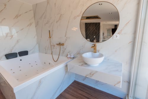 Séjour de Luxe à Saint-Jean-Bonnefonds : Chambre Dubaï** Vivez un séjour de luxe dans notre chambre Dubaï, offrant une vue magnifique sur la nature, à Saint-Jean-Bonnefonds, près de Saint-Étienne dans la Loire. Plongez dans une atmosphère de sophistication avec des murs en marbre blanc et doré, créant une ambiance luxueuse et minimaliste. Détendez-vous dans notre jacuzzi tout en admirant la vue panoramique, puis profitez d'une soirée cinéma sur notre grand écran de 189 cm avec Netflix, pour une expérience inoubliable.