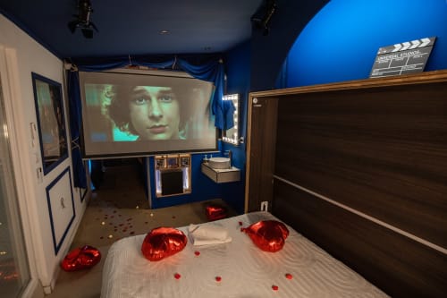 Vivez une expérience cinématographique unique dans la suite Cinéma, une Love Room sur le thème du cinéma. Profitez d'un jacuzzi encastré dans le sol pour des moments de détente luxueux et d'un grand vidéoprojecteur de 250 cm pour des soirées films inoubliables. Avec son ambiance élégante et ses équipements haut de gamme, cette suite est idéale pour les amateurs de cinéma et de relaxation. Réservez la suite Cinéma et offrez-vous une escapade romantique sous les projecteurs. a deux pas de Saint Etienne.