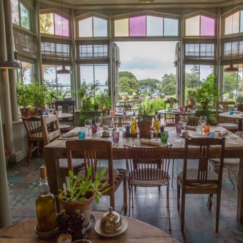 Three Little Pigs hotel dining room with large windows overlooking gardens in Blandford Forum