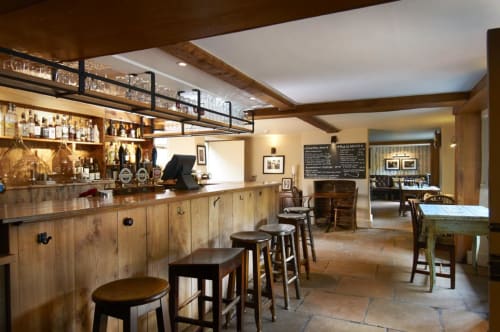 Three Little Pigs pub bar in Blandford Forum with wooden counter, bar stools, and cozy seating area