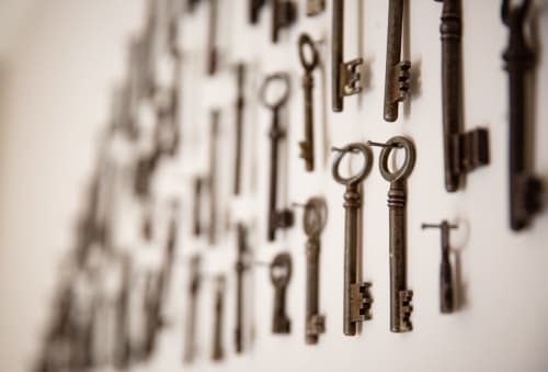 Vintage skeleton keys displayed on white wall at Three Little Pigs hotel in Blandford Forum