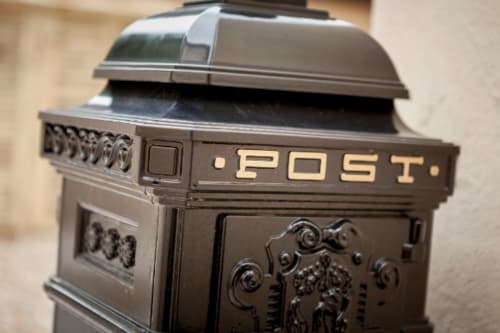 Ornate black cast iron post box with decorative details at Three Little Pigs hotel, Blandford Forum