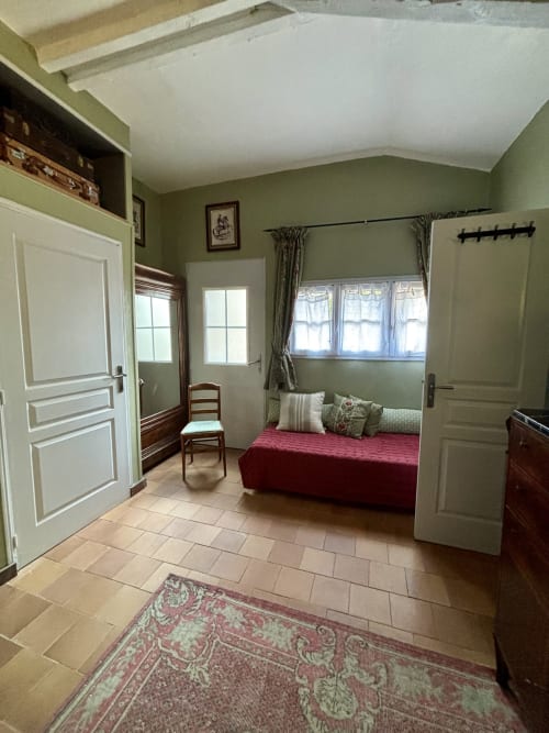 Chambre Fleur bedroom at Domaine Du Commandeur B&B in Mondragon with red bed, green walls, and garden view