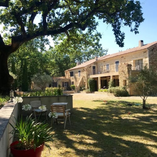 Cour du Domaine Du Commandeur à Mondragón avec bâtiment en pierre, pelouse ombragée et salon extérieur