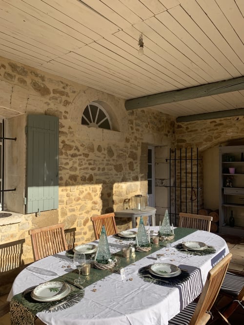 Elegant dining room at Domaine Du Commandeur with stone walls, wooden beams, and festively set table for holiday dinner