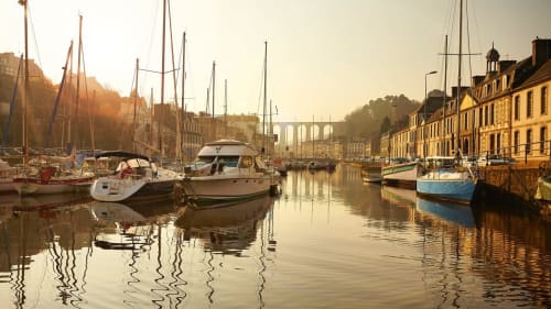 Peaceful harbor at sunrise with sailboats and traditional buildings, Pleyber-Christ Brittany