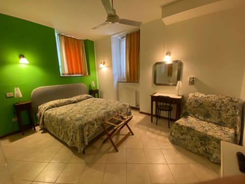 Camera Cyan presso Alloggio Le Casette a Verona con letto matrimoniale, letto singolo, parete accent verde e comfort moderni