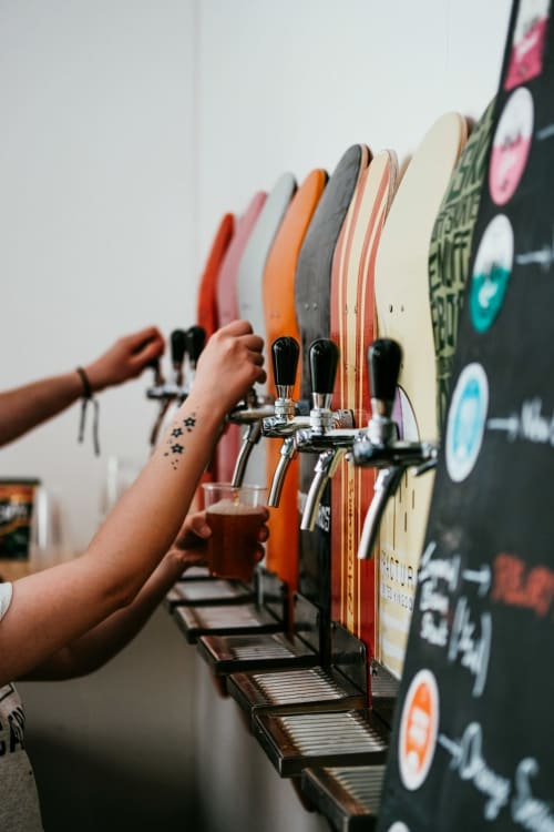 Craft beer tap system at Grapevine Studio in Waterbeach, Cambridge with colorful beer taps and drip trays
