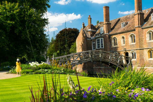 Grapevine Studio in Waterbeach, Cambridge: brick manor house with wooden bridge over moat, manicured gardens, and purple