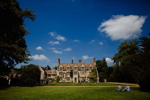 Grapevine Studio mansion in Waterbeach, Cambridge with manicured lawns, stone architecture, and visitors enjoying the grounds