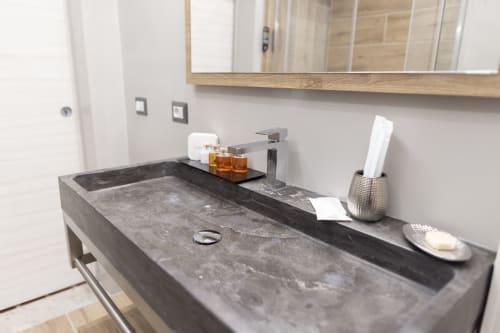 Lavabo moderno con top in pietra scura, rubinetteria contemporanea e servizi al B&B I Mori di Catania