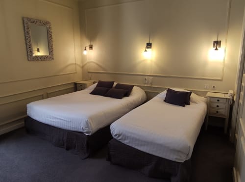 Triple room at Le Pavillon Saint Martin Hotel in Souillac with two queen beds, pendant lights, and city views