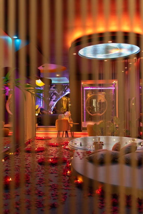 Suite spa luxueuse à L'Insolite avec bains à remous luminescents, cabines privées néon et pétales de roses au spa de Toulouse