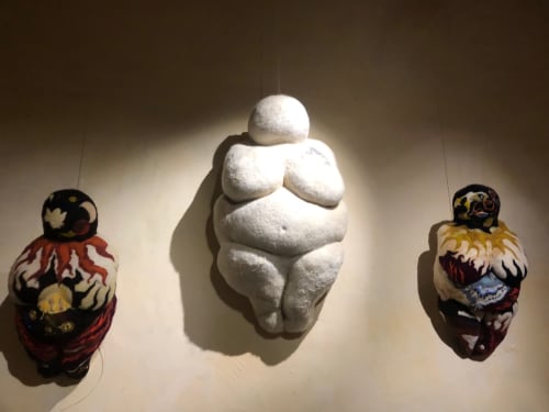 Trois sculptures suspendues au Domaine de l'Ocrerie : figurine Vénus en pierre blanche encadrée de vases céramiques décorés