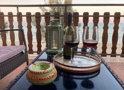 Vino e aperitivo sulla terrazza con vista mare della Noemi Holiday House ad Agnone Bagni, Italia