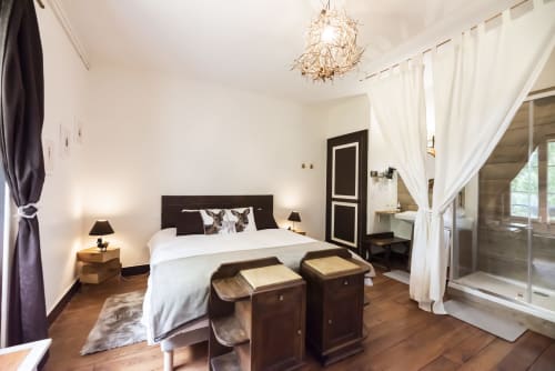 Spacious bedroom at Baccara Lodge in Arengosse with king bed, dark headboard, white bedding, and modern ensuite bathroom