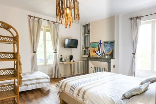 Bright bedroom at Baccara Lodge B&B in Arengosse with twin beds, wooden furnishings, fireplace, and coastal décor