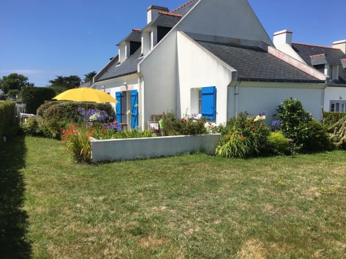 Charmante maison blanche aux volets bleus à Locmaria, Belle-Île-en-Mer, avec jardin aux fleurs colorées et jaune