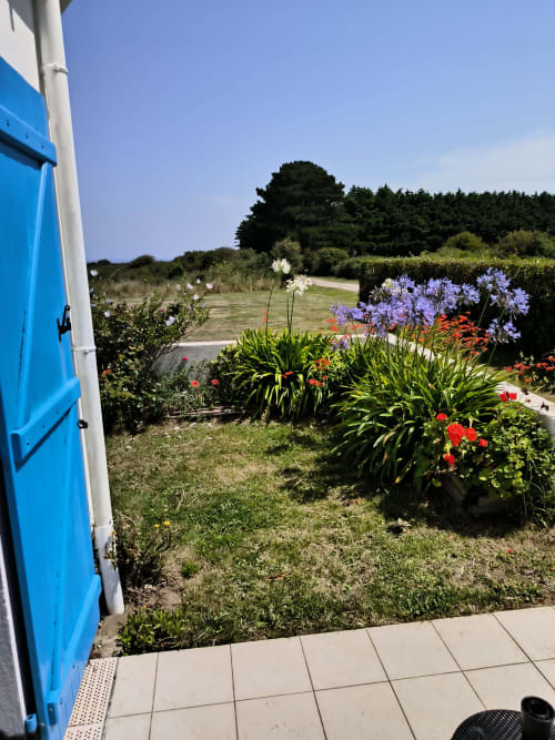 Jardin coloré avec agapanthes violettes et fleurs rouges à l'appartement Loc'Maria, Belle Île en Mer, Bretagne