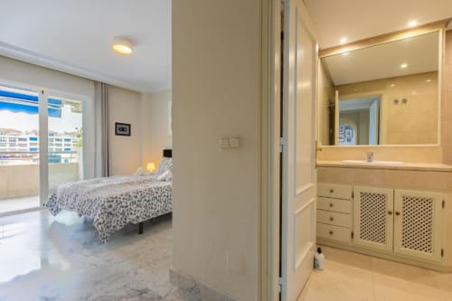 Modern bedroom with ensuite bathroom in Marina Banús apartment, Marbella with balcony view