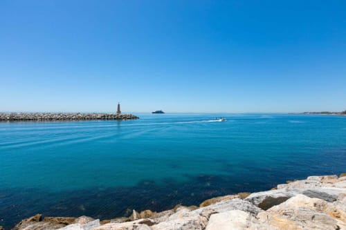 Crystal blue Mediterranean Sea with rocky coastline and Puerto Banús marina in Marbella, Spain