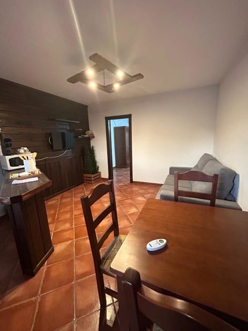 Cocina y comedor moderno en Mérida con pisos de barro, muebles de madera y luminarias contemporáneas