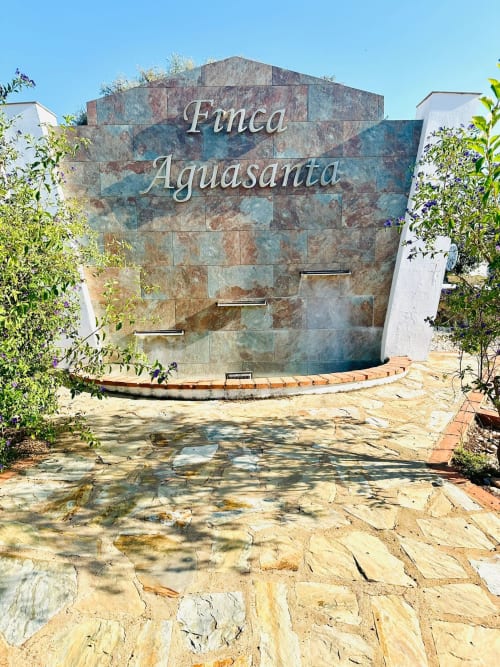Entrada de Finca Aguasanta en Mérida con arquitectura de piedra y vistas a las montañas