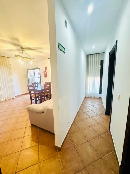 Pasillo y sala de estar del apartamento Gestyp-AT en Mérida con baldosas de barro y amueblamiento moderno