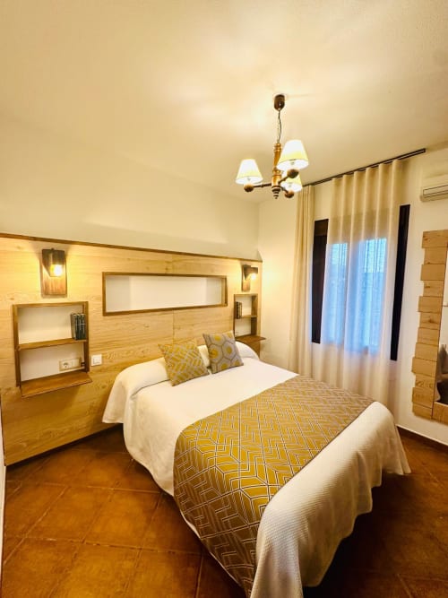 Moderno apartamento dormitorio en Gestyp-AT de Mérida con cabecera de madera, camas gemelas y vistas a la montaña