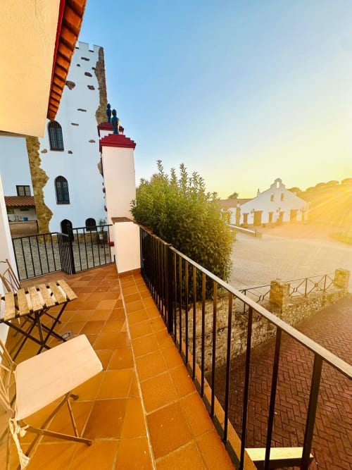 Balcón de terracota con vistas a la montaña, torre blanca y patio del apartamento Gestyp-AT en Mérida