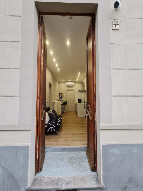Ulazna vrata Raymihome apartmana u Torinu prikazujući moderni studio s parketnom podlogom, ugrađenim osvjetljenjem i suvremenim dizajnom