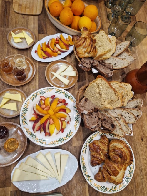 Petit-déjeuner servi à Maisonaurinko B&B à Thénon : viennoiseries, pain, fromage, fruits et agrumes