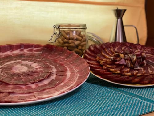 Carnes curadas y frutos secos presentados en platos del hotel Gestyp-AT en Mérida, España