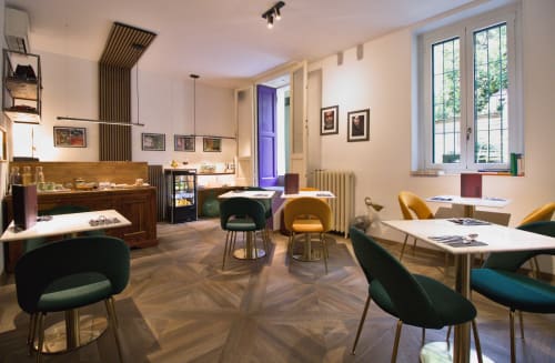 Lobby lounge di Porta Tosa Milano con sedie moderne, vetrine in legno e grandi finestre