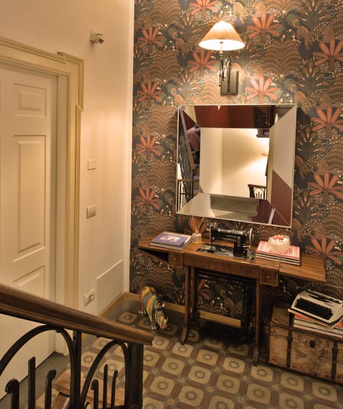 Elegante toilette della camera da letto presso Porta Tosa B&B Milano, con carta da parati floreale ornamentale e scrivania in legno con specchio