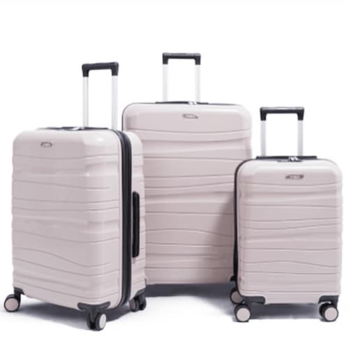 Three pale pink hardshell luggage suitcases with black handles and wheels for Paris travel.