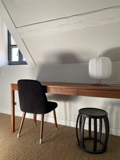 Espace de travail de la chambre Colette à La Guirtelle avec bureau en bois, chaise noire et lampe suspendue blanche