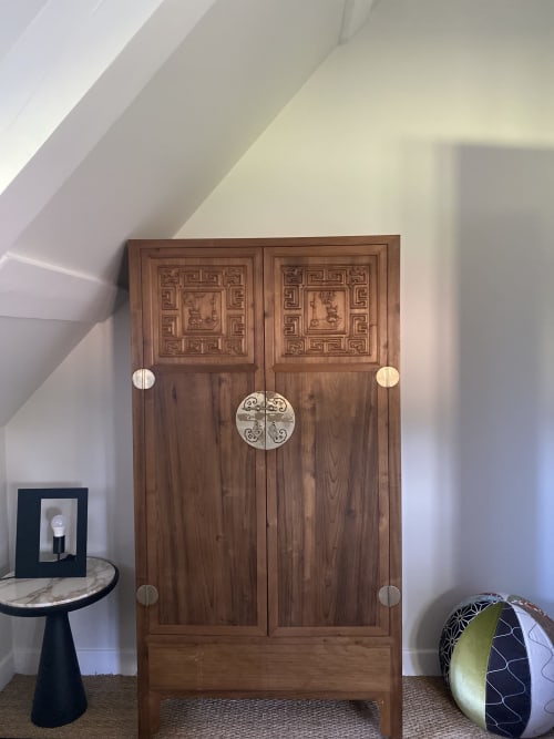 Armoire asiatique en bois aux panneaux sculptés dans la chambre Colette de la Maison d'hôtes La Guirtelle, Lainsecq