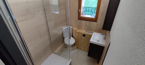 Salle de bain moderne à L'étape Du Fanfoué à Chamrousse avec douche, toilettes et vasque avec finitions en bois