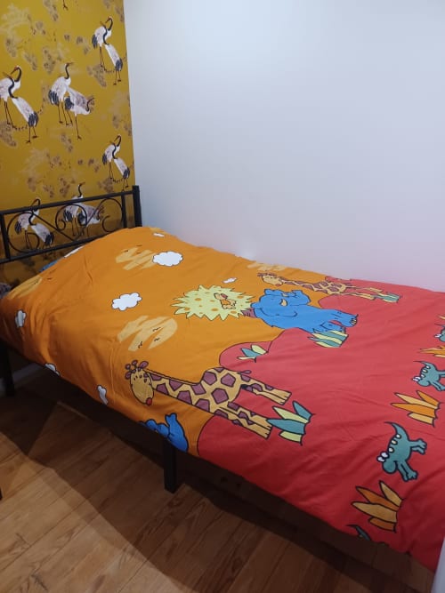 Literie colorée pour enfants avec animaux sur un lit au gîte Accolade à Châteaudun, France