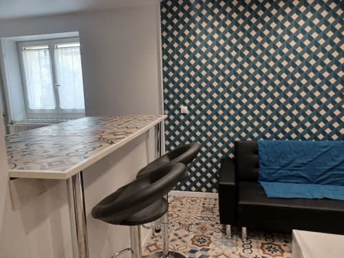 Cottage Accolade à Châteaudun avec papiers peints à motifs, bar moderne, canapé bleu et portes vue sur les monuments.