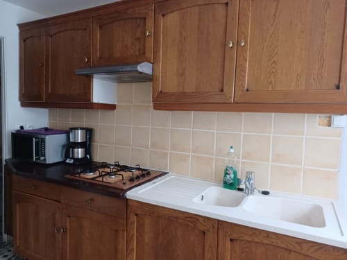 Cuisine de cottage à Accolade Châteaudun avec meubles en bois, cuisinière à gaz et évier double