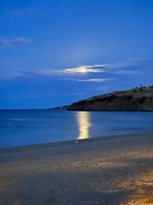 Spiaggia al chiaro di luna presso Noemi Holiday House ad Agnone Bagni, Italia con acque blu tranquille e costa rocciosa