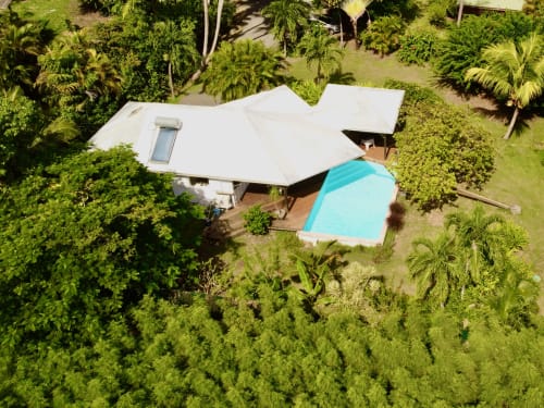 Vue aérienne de la villa Villas aux Antilles à Saint-François avec piscine turquoise, toit blanc, entourée de jardins tropicaux
