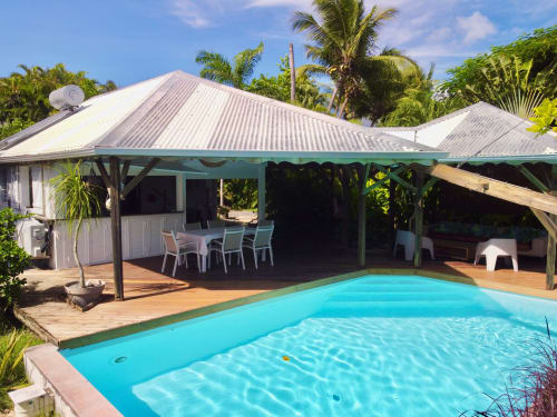 Villa tropicale avec piscine turquoise, terrasse couverte pour dîner et jardin de palmiers luxuriants à Saint-François, Guadeloupe