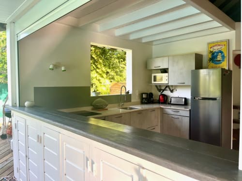 Cuisine moderne de la villa Villas aux Antilles à Saint-François avec appareils en acier inoxydable, armoires blanches et vue sur le jardin